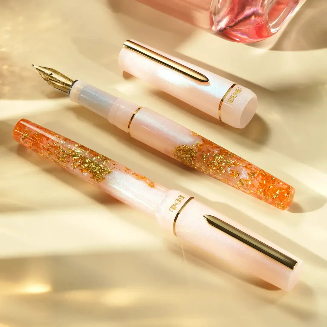 Benu Haute Flair Füllfederhalter aus perlrosanem Resin mit tanzenden Goldflocken, facettiertem Korpus und vergoldeter Feder und Clip