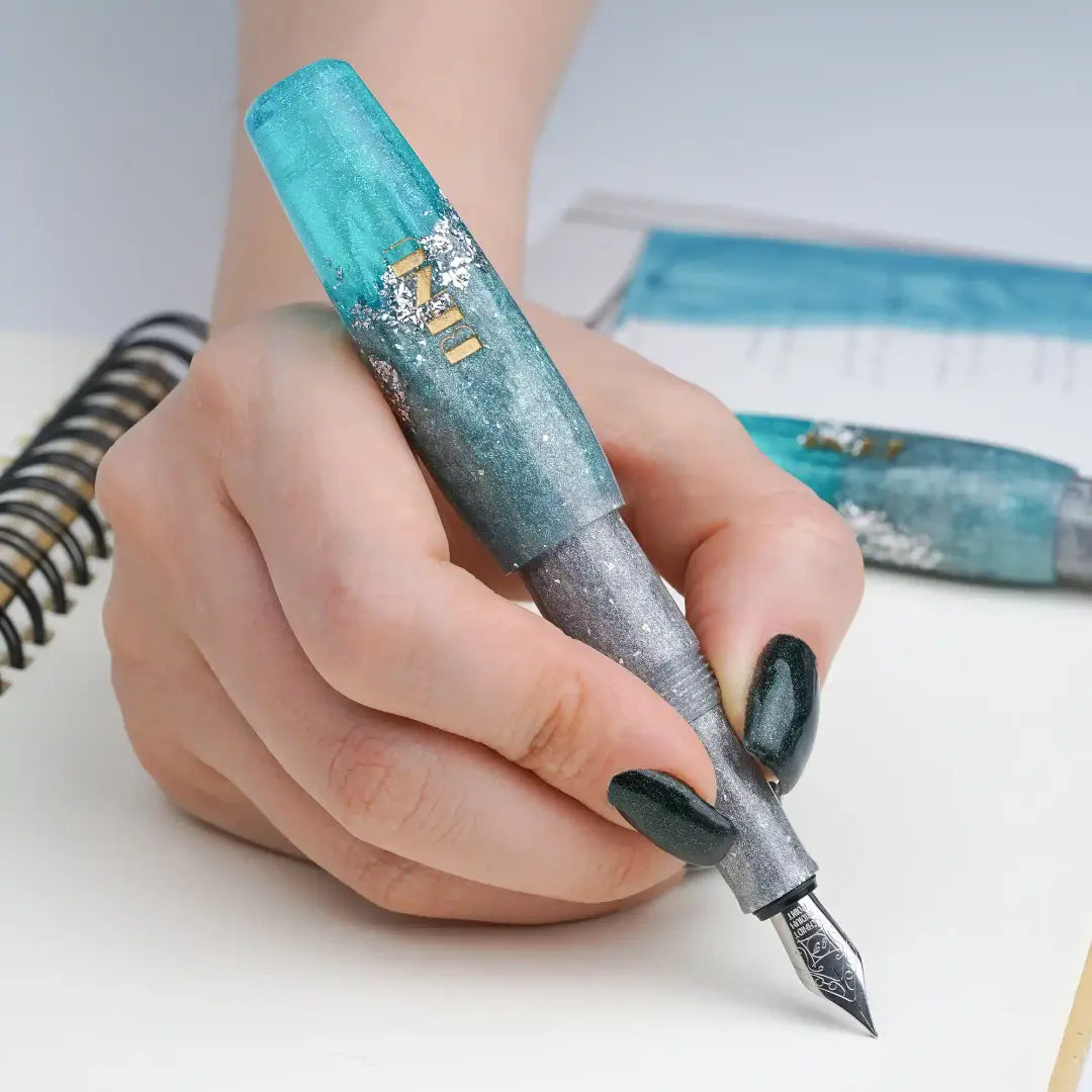 Benu Pixie Aqua Glow Füllfederhalter aus leuchtendem Aqua und schimmerndem Silber mit Silberglitzerakzenten, handgemalt, vergoldete Schmidt-Feder und Edelstahlclip