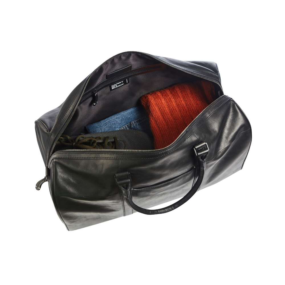 Interior view of the black leather weekend bag showing clothing items packed inside.