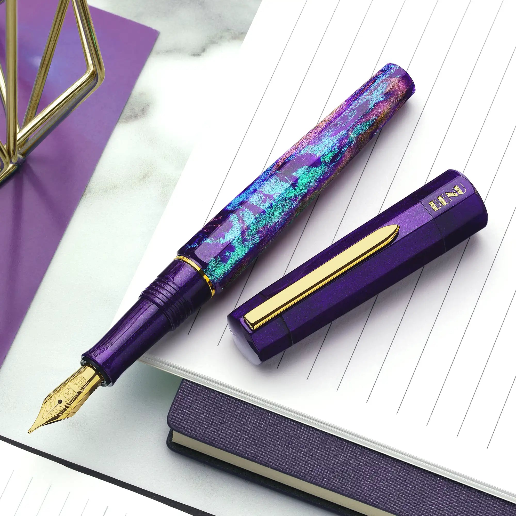 Benu Euphoria Opera Füllfederhalter aus lila prismatischem Resin mit Pflaume, Smaragdgrün und Magenta-Reflexen sowie vergoldetem Clip und Feder