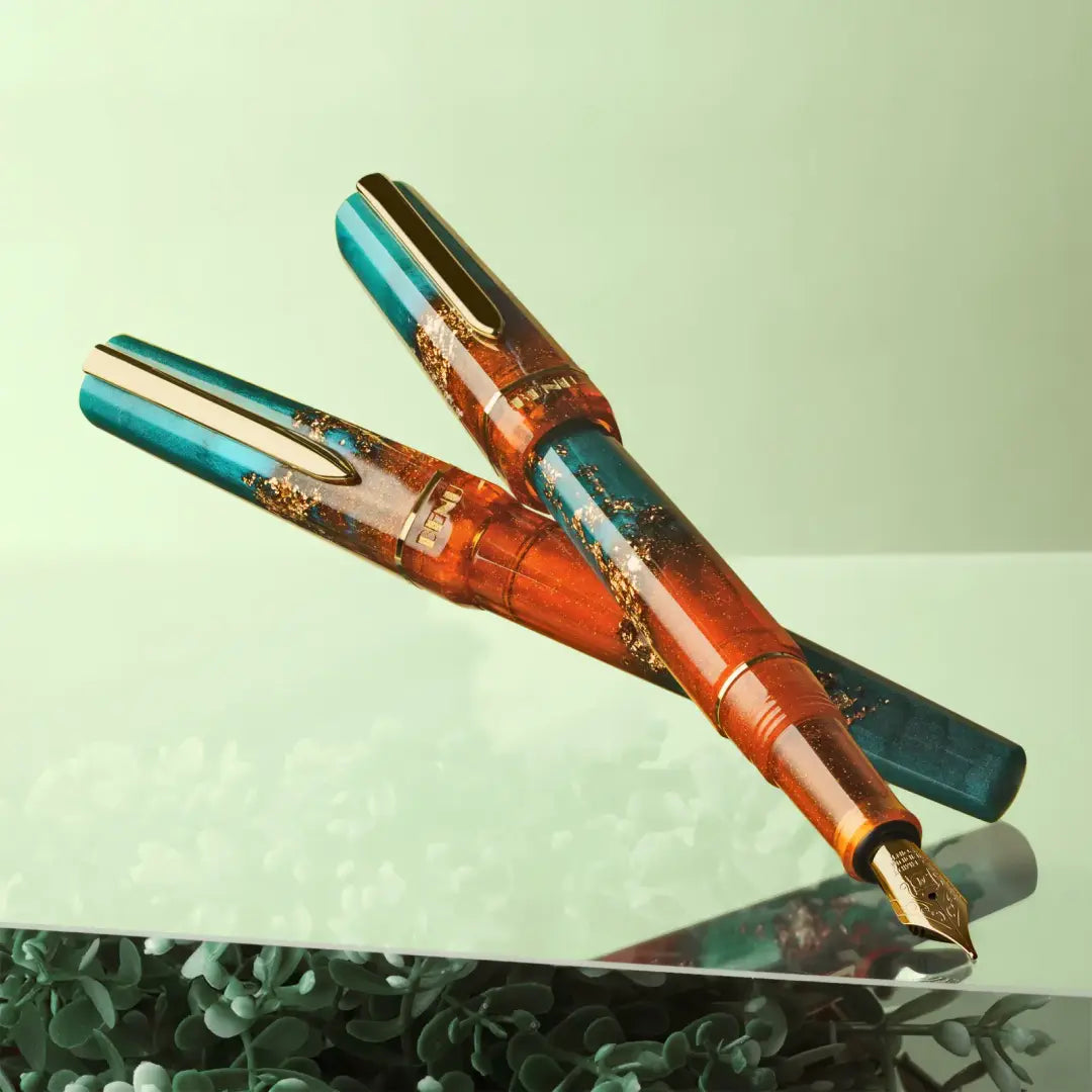 Benu Haute Chic Füllfederhalter aus orangefarbenem und tealem Resin mit Goldstreifen, facettiertem Korpus und vergoldeter Feder und Clip