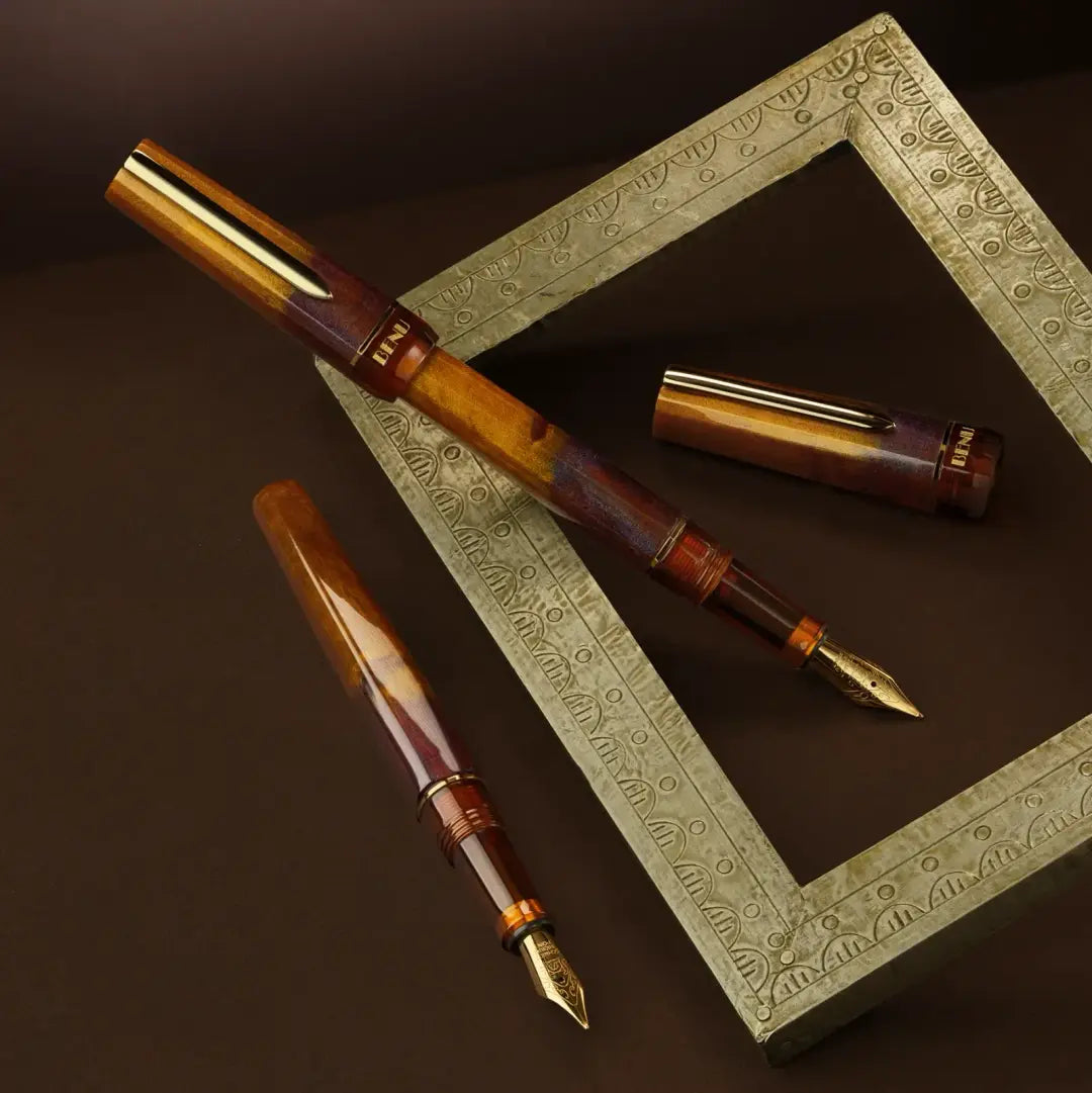 Benu Haute Decadence Füllfederhalter aus karamellfarbenem und ambernem Resin mit facettiertem Korpus und vergoldetem Clip und Feder