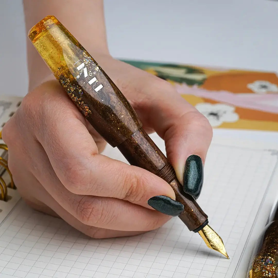 Benu Pixie Honey Bronze Füllfederhalter aus bronzefarbenem und honiggelben Resin mit Goldglitzerakzenten, handgemalt, vergoldete Schmidt-Feder und vergoldeter Clip