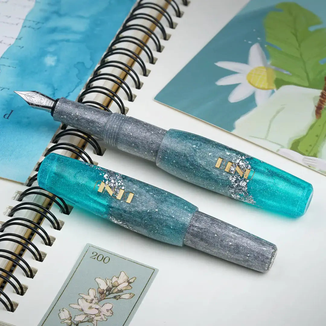 Benu Pixie Aqua Glow Füllfederhalter aus leuchtendem Aqua und schimmerndem Silber mit Silberglitzerakzenten, handgemalt, vergoldete Schmidt-Feder und Edelstahlclip