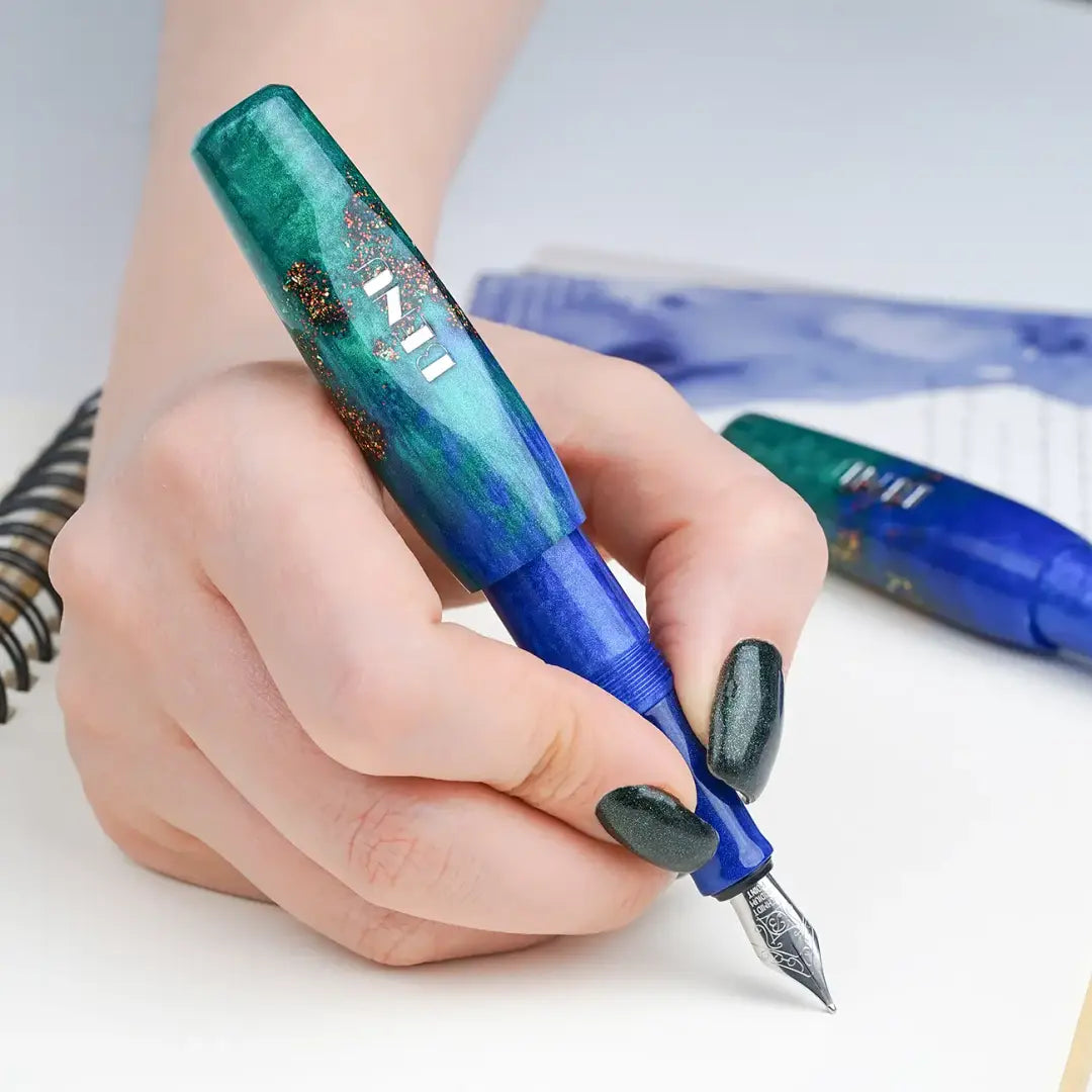 Benu Pixie Emerald Sea Füllfederhalter aus smaragdgrünem und blauem Resin mit roten Glitzerakzenten, handgemalt, vergoldete Schmidt-Feder und Edelstahlclip