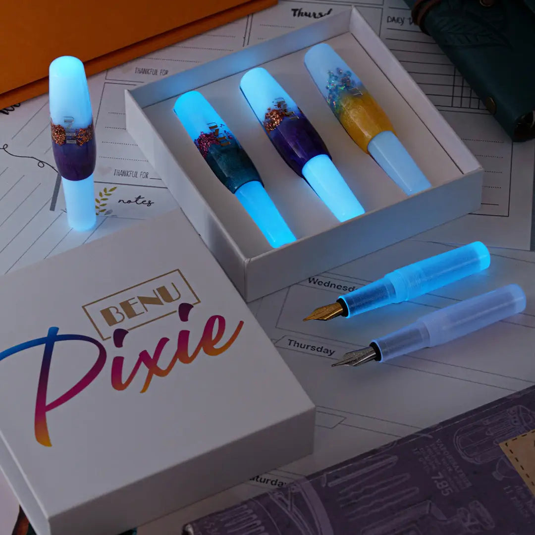 Benu Pixie Luminous Haze Füllfederhalter aus leuchtendem Resin mit schimmernden Flocken und neonblauem Glow-in-the-Dark-Effekt im kompakten Miniaturformat