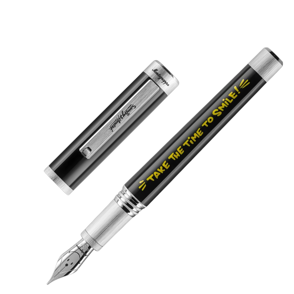 Montegrappa Smiley® 50th Anniversary Füllfederhalter with a distinctive yellow barrel and stainless steel nib, resting in its case.